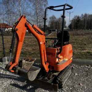 Pomarańczowa minikoparka jcb na żwirowym podłożu